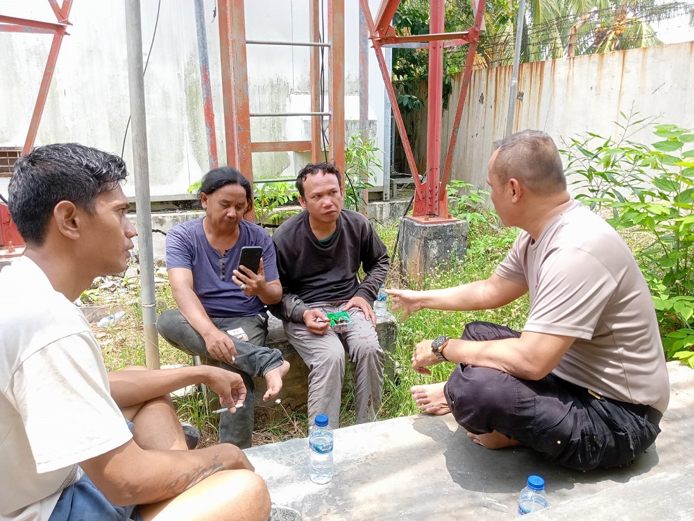 Polisi akhirnya berhasil membujuk turun pria bernama Iman (tiga dari kiri) yang memanjat dan bertahan di atas tower selama tiga hari, Jumat (27/3). F. Dok. Polsek untuk Batam Pos