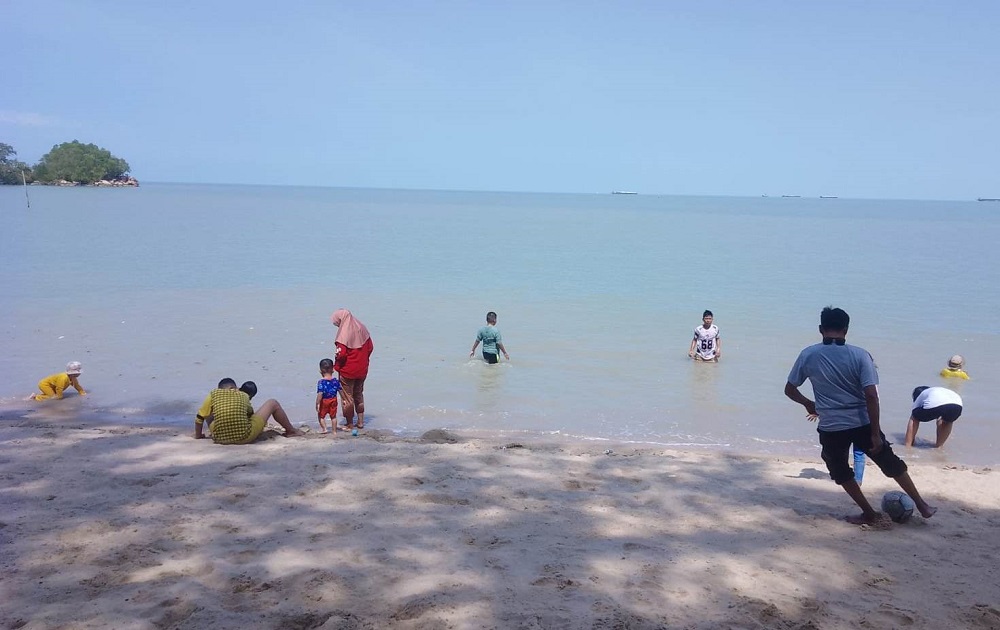 Pengunjung menikmati suasana Pantai Pongkar, Karimun, saat libur Lebaran dengan duduk santai bersama keluarga. F. Tri Haryono/Batam Pos