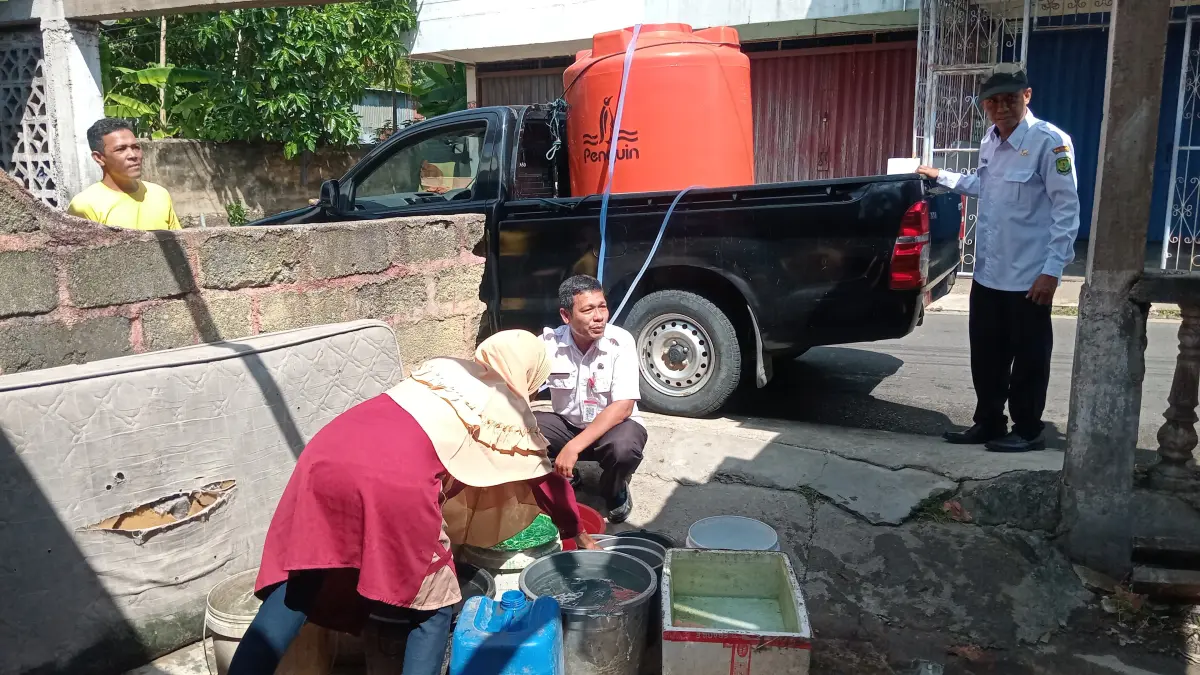 PETUGAS Kelurahan Sei Jang saat menyalurkan air ke rumah warga, Rabu (1/4/2026). F. Mohamad Ismail/Batam Pos