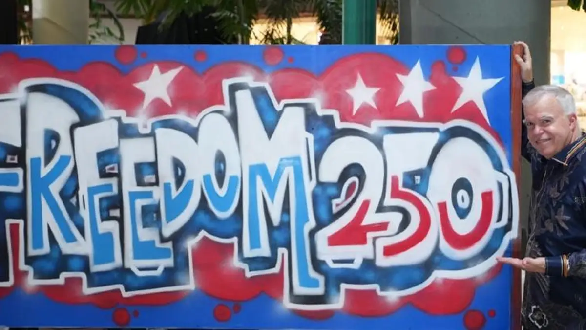 KUAI Peter Haymond berpose di depan karya seni grafiti Freedom 250 karya Edhie Haryo. Edhie, yang lebih dikenal sebagai Abo, telah mengikuti program residensi seniman Next Level 2026 di Yogyakarta dan Solo. F Konsulat AS di Surabaya untuk Batam Pos