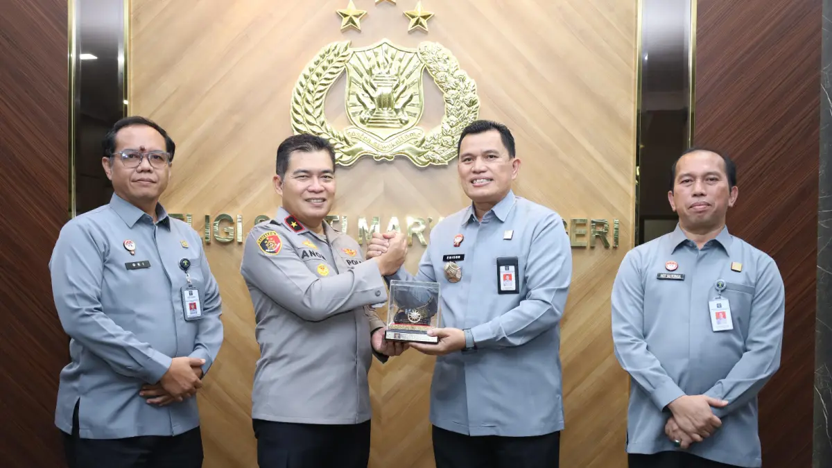 Kepala Kanwil Kemenkum Kepri, Edison Manik saat memberikan cendramata kepada Wakapolda Kepri. F. Kemenkum Kepri untuk Batam Pos