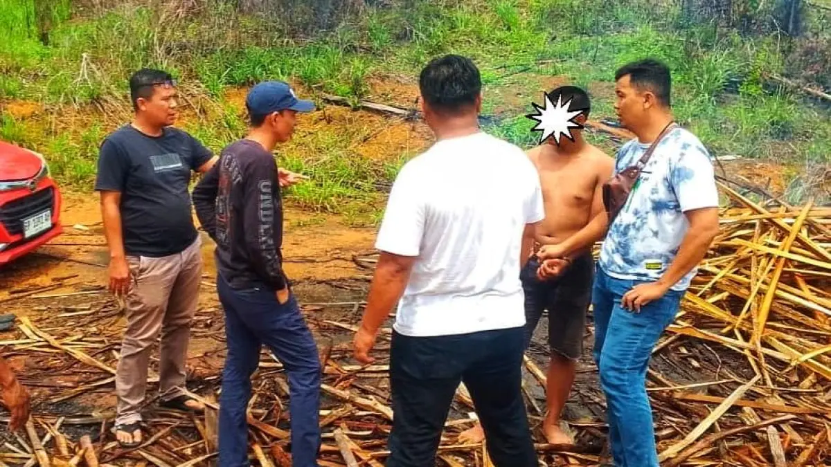 PETUGAS mengamankan pelaku penganiayaan mantan bos di sedang bekerja memotong kayu di Jalan Mekar Sari, Tanjunguban, Kecamatan Bintan Utara. F.Polsek Bintan Utara untuk Batam Pos