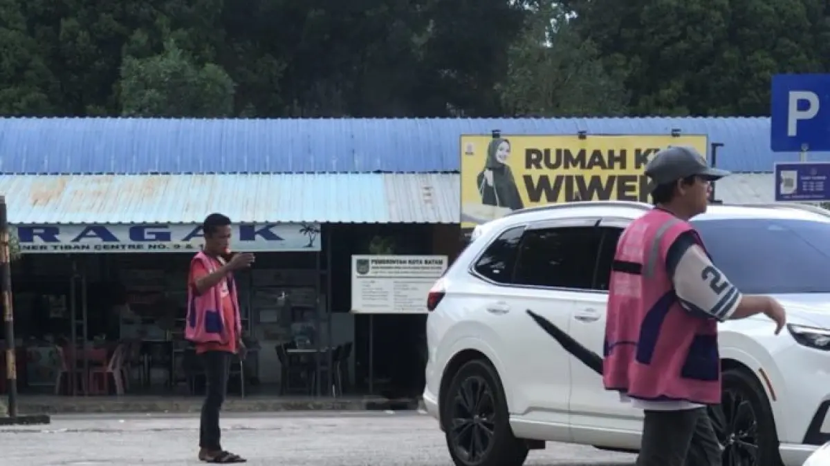 Dua juru parkir liar masih beroperasi di kawasan Tiban Center Pujasera, Jumat (24/4) siang, meski telah terpasang plang resmi bebas parkir. F. M. Sya’ban / Batam Pos