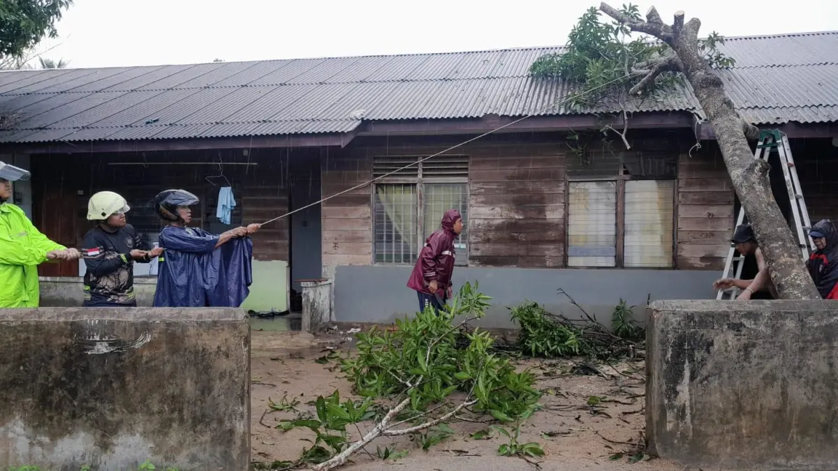 PETUGAS mengevakuasi pohon tumbang yang menimpa rumah warga di Jalan Bhakti Sosial, Tanjunguban, Kecamatan Bintan Utara, pada Senin (27/4/2026). F.Damkar Tanjunguban untuk Batam Pos