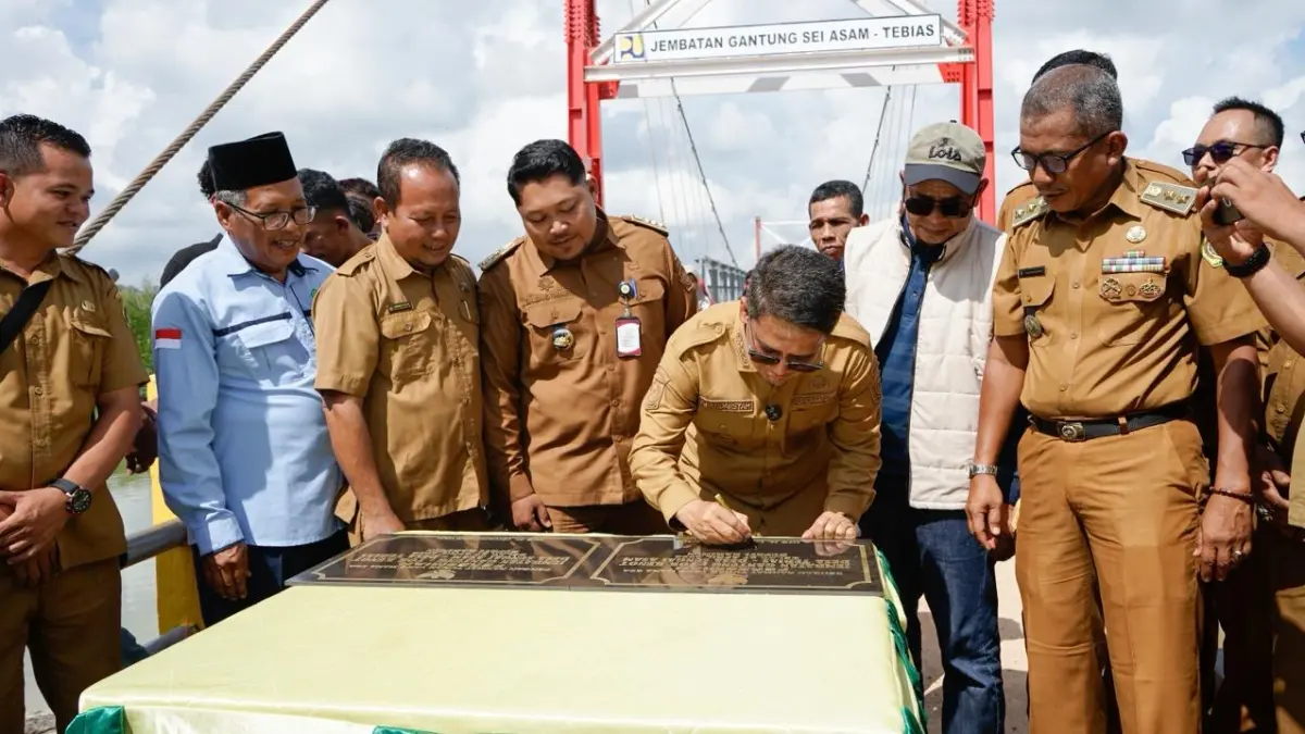 BUPATI Karimun, Iskandarsyah memotong pita sebagai tanda peresmian Jembatan Gantung Tok Kenot kemarin. F Sandi Pramosinto/Batam Pos