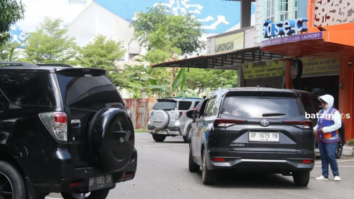 Salah seorang juru parkir (jukir) di kawasan Greenland, Batam Center, Batam, terlihat mengatur kendaraan di pinggir jalan. Foto: M. Sya’ban/Batam Pos