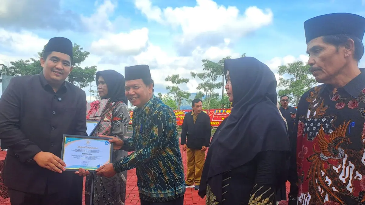 BUPATI Bintan, Roby Kurniawan memberikan piagam penghargaan kepada para guru yang memasuki masa pensiun usai peringatan Hardiknas di Halaman Kantor Bupati Bintan, Bintan Buyu, Selasa (5/5/2026). F.Slamet Nofasusanto/Batam Pos