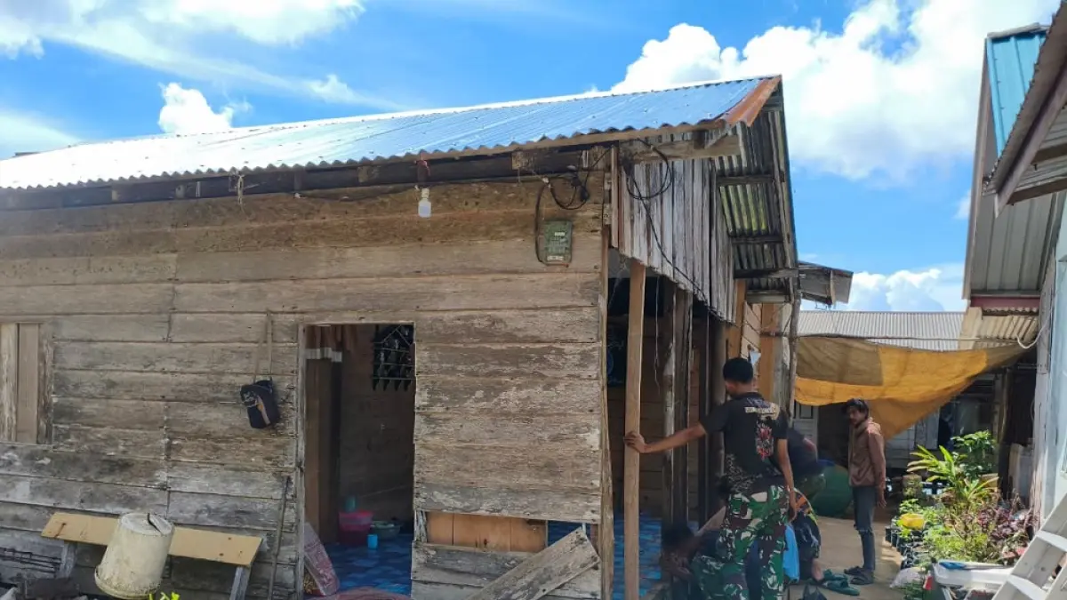 Personel TNI dibantu warga membangun kembali rumah Mila yang rusak akibat terjangan ombak. Foto: Ihsan Imaduddin/Batam Pos