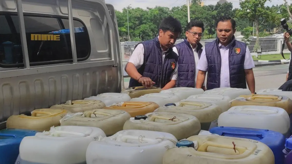 Kasat Reskrim Polresta Barelang Kompol M Debby Tri Andrestian, menunjukan barang bukti BBM pertalite yang diamankan saat ekspos terkait kasus penyalahgunaan BBM subsidi pertalite di Mapolresta Barelang, Rabu (6/5). F Cecep Mulyana/Batam Pos