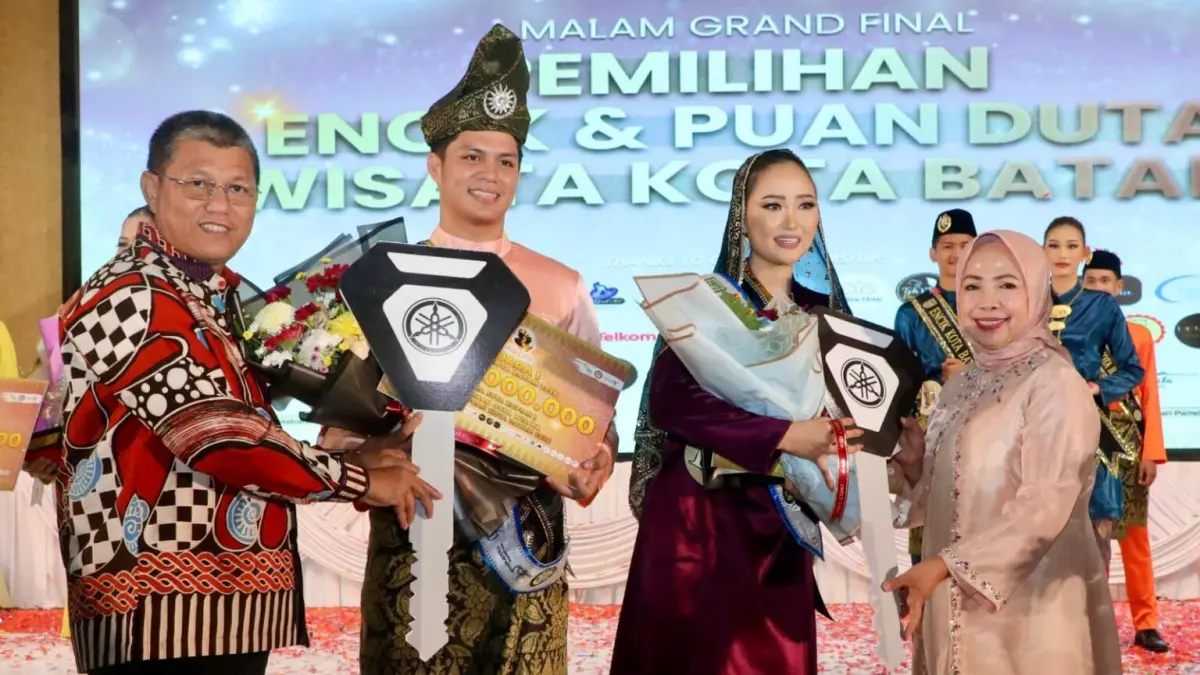 Sekda Batam, Firmansyah, bersama Ketua DWP Batam, Erdawati Firmansyah, menyerahkan hadiah kepada pemenang Duta Wisata Encik dan Puan Kota Batam 2026 di Harmoni One, Sabtu (9/5/2026) malam. 