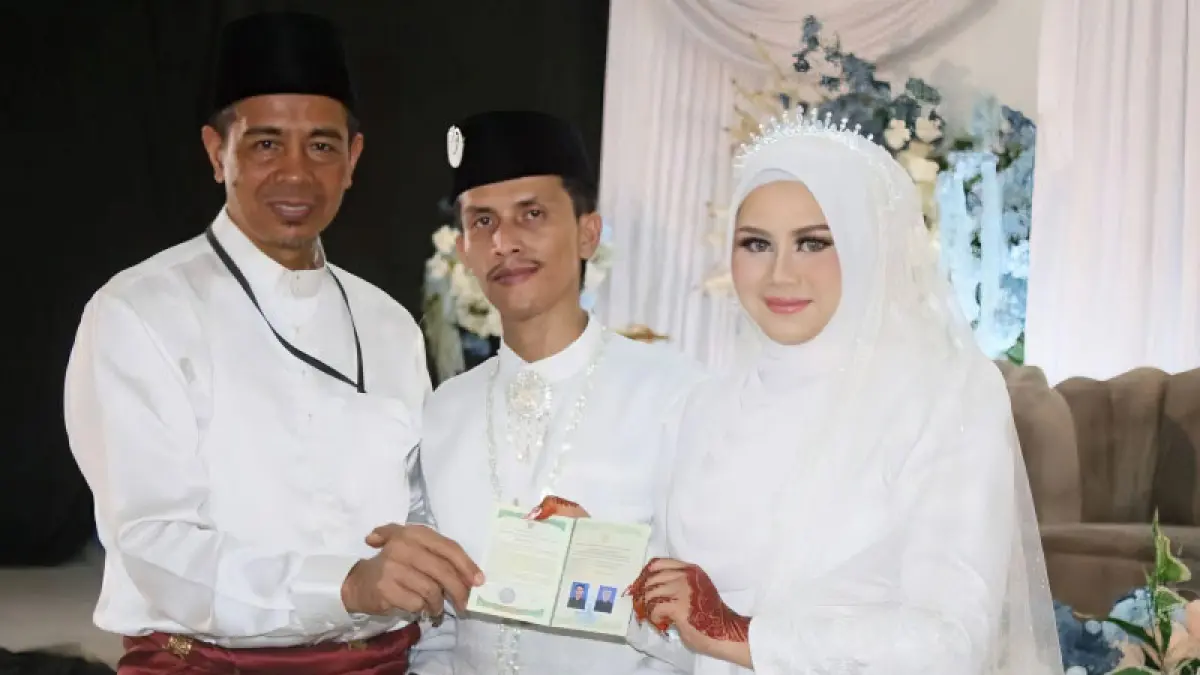  Kepala Kemenag Kota Tanjungpinang Erizal menyerahkan buku nikah kepada pasangan suami-istri yang baru saja menikah, Jumat (15/5/2026). ANTARA/HO-Humas Kemenag Tanjungpinang
