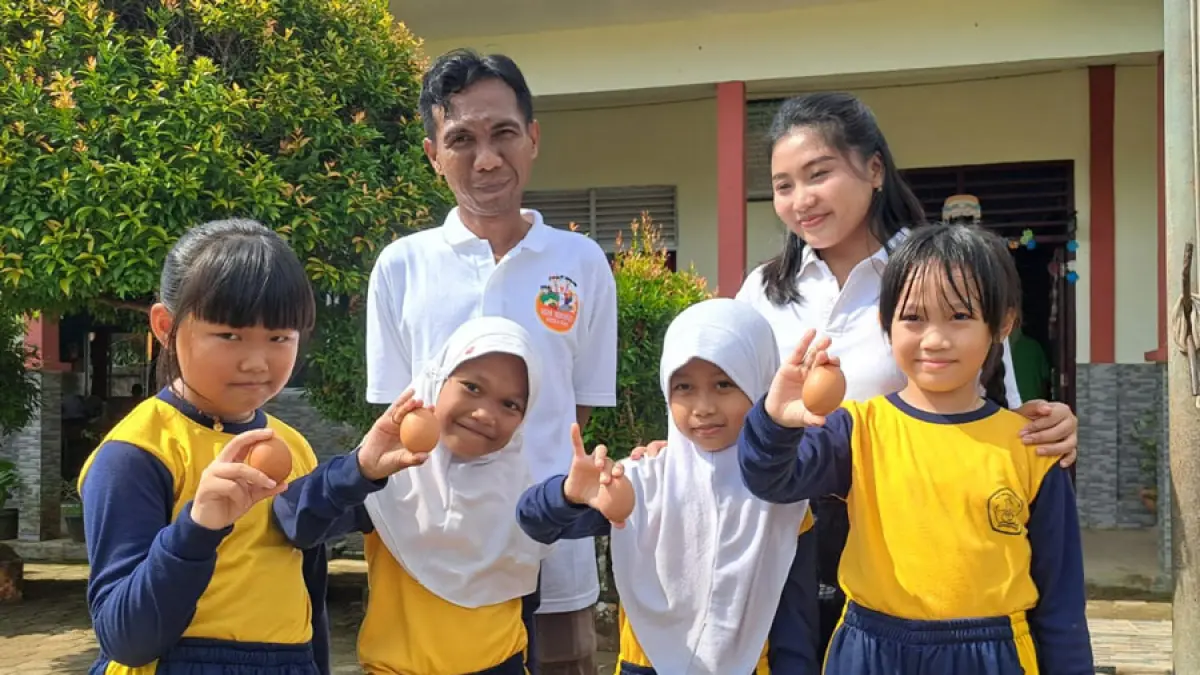 Sejumlah siswa menerima telur ayam yang dibagi pihak Japfa di SD Negeri 001 Teluk Bintan pada Kamis (21/5/2026). F.Slamet Nofasusanto/Batam Pos.