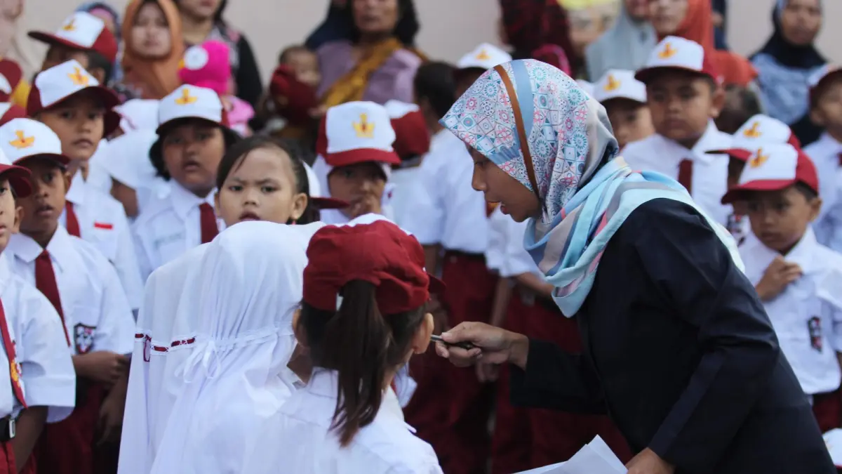 Ilustrasi guru mendampingi siswa pada hari pertama sekolah tahun ajaran baru. (Dery Ridwansah/JawaPos.com)