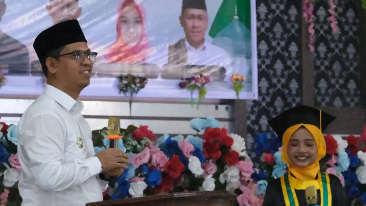 Bupati Iskandarsyah berfoto bersama seorang santriwati usai wisuda santri dan santriwati TPQ se-Kecamatan Kundur Barat.  F. Sandi Pram / Batam Pos