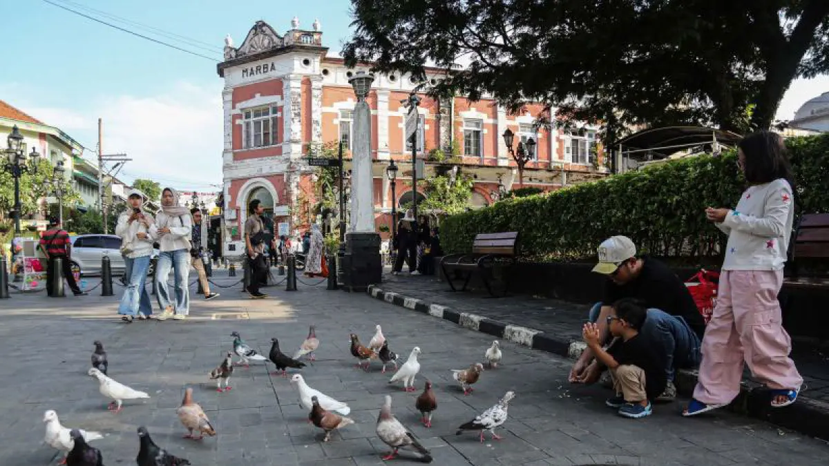 - Sejumlah wisatawan domestik memberi makan burung merpati di kawasan wisata Cagar Budaya Nasional Kota Lama, Semarang, Jawa Tengah, Minggu (26/4/2026). (ANTARA FOTO/Makna Zaezar/wsj) 
