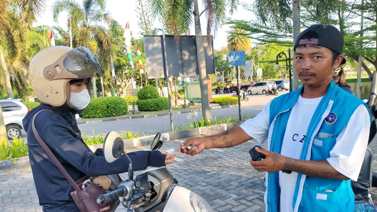 Febri, petugas parkir di RSUD Muhammad memberikan tiket parkir yang dicetak dari&nbsp;
mesin Emboss. F Sandi Pramosinto/Batam Pos