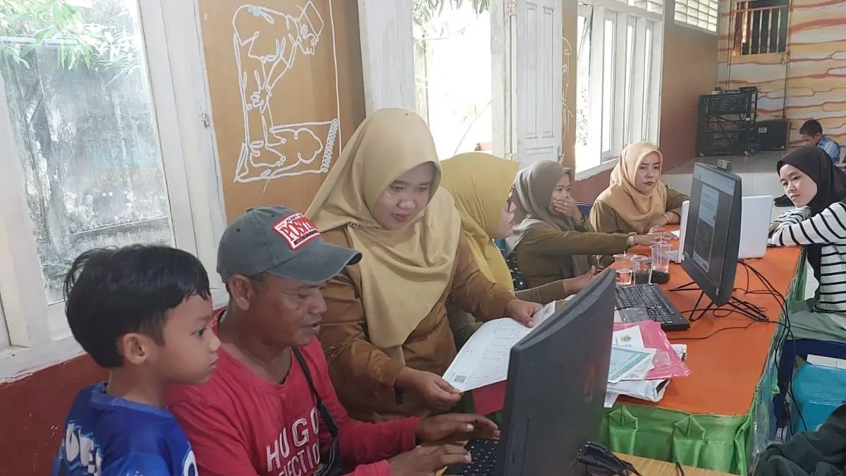 Suasana SPMB Online di Karimun. Guru membantu orang tua siswa. F Sandi Pramosinto/Batam Pos