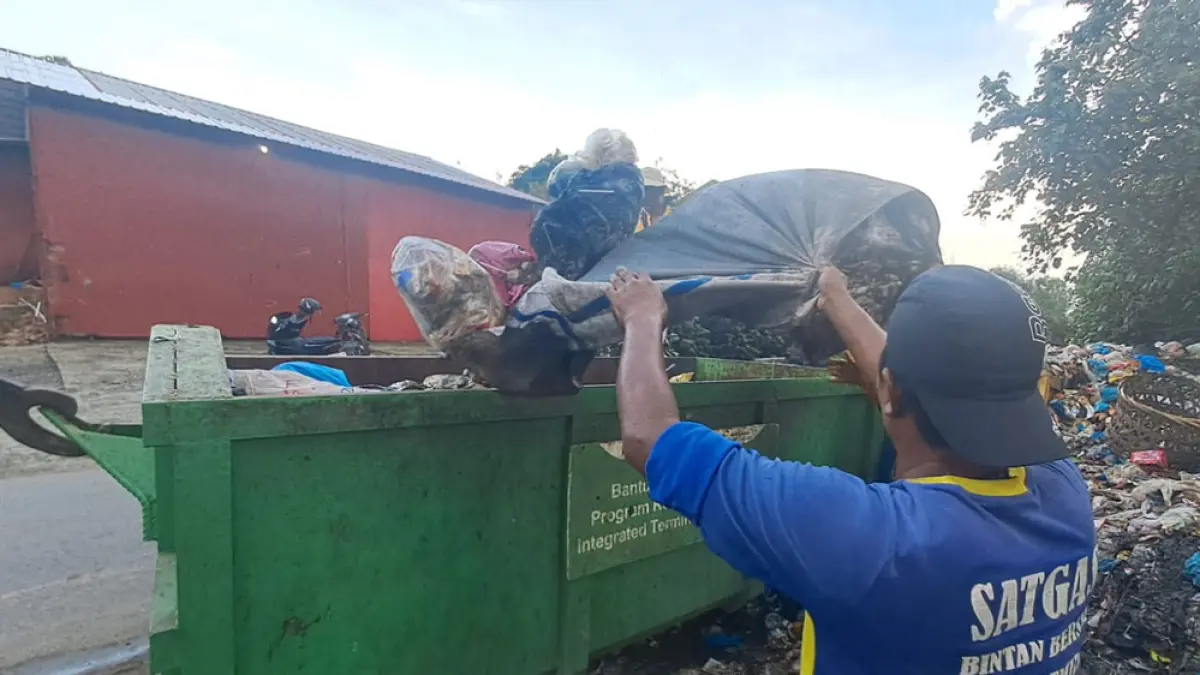 
Petugas kebersihan mengangkut tumpukan sampah ke dalam truk di Jalan Nipah, Tanjunguban, Kamis (11/6/2026). Penanganan sampah di Bintan Utara sempat terkendala armada yang rusak serta bertambahnya jarak tempuh menuju TPA Kijang.  F. Slamet N / Batam Pos