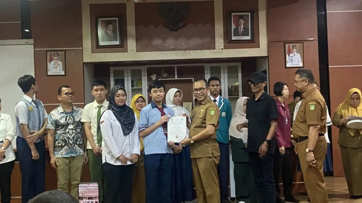 Kepala Disdik Batam Hendri Arulan sedang memberikan sertifikat untuk anak-anak yang meraih skor tertinggi pada TKA 2026 di Batam, Kepri (15/6/2026). (ANTARA/Amandine Nadja) 