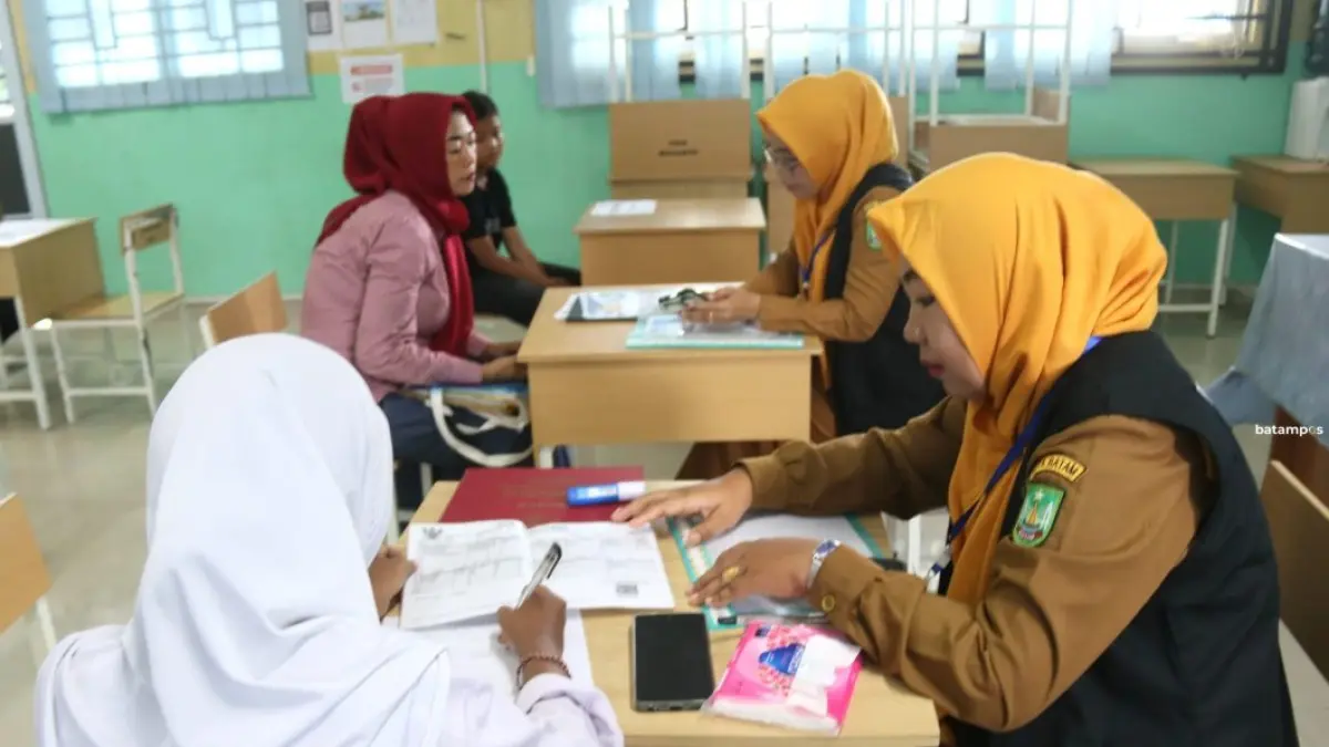 Orang tua calon siswa SMP saat melakukan pendaftaran anaknya di SMPN 43 Batam, Senin (8/6). Hari pertama SPMB dibuka untuk jalur afirmasi dan prestasi. F.Cecep Mulyana/Batam Pos