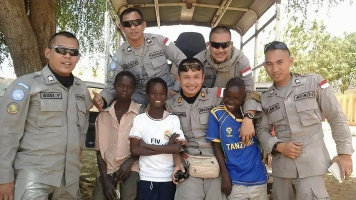 Chris Tamba (tengah) bersama tim polisi Indonesia foto bersama warga lokal saat bertugas menjadi Pasukan Perdamaian PBB di Sudan, Afrika Utara. F Dok pribadi untuk Batam Pos