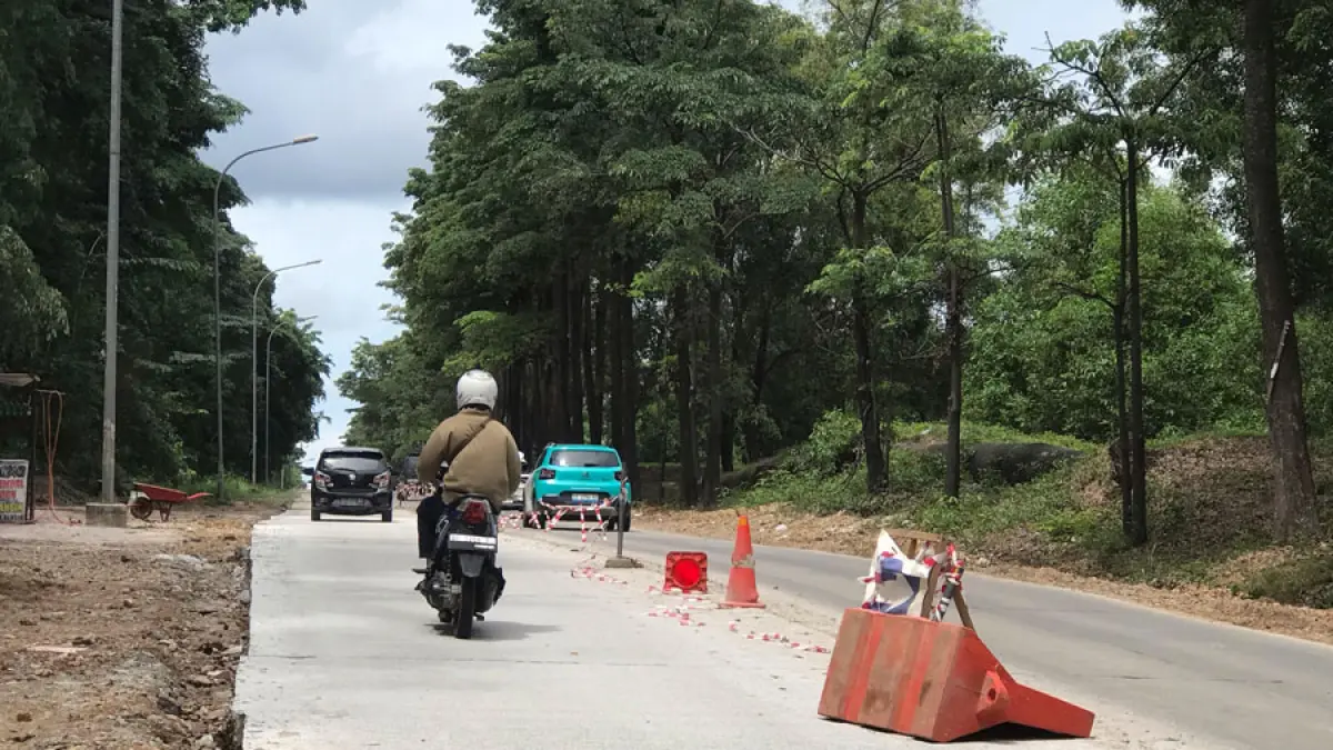 Pengendara melintas di ruas Jalan S Parman, Batam, yang telah selesai dilakukan pengecoran beton dan sudah dapat dilalui kendaraan meski proses pengaspalan menyeluruh masih berlangsung, Minggu (21/6). Foto: M. Sya