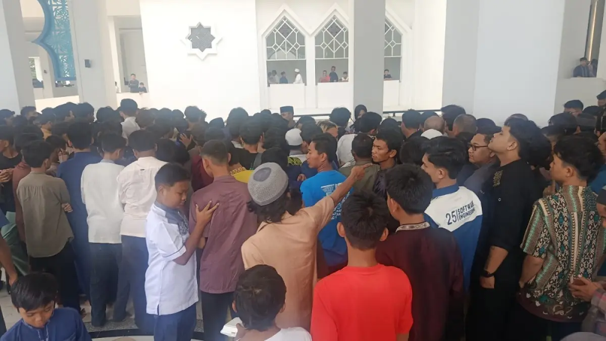 Jemaah, mulai dari anak-anak hingga orang dewasa, antre nasi kotak usai salat Jumat di Masjid Agung Raja Hamidah, Jumat (26/6). Momen pembagian sedekah itu memicu kerumunan hingga sebagian nasi kotak ada yang terjatuh. Foto: M. Sya