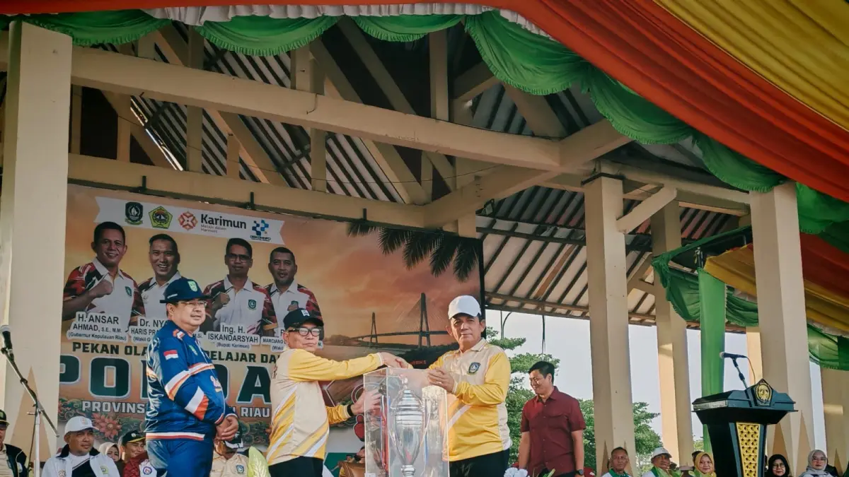 Gubernur Kepri, Ansar Ahmad menyerahkan piala bergilir kepada Ketua Panitia Pelaksana Popda X Provinsi Kepri, Darson. F Sandi Pramosinto/Batam Pos