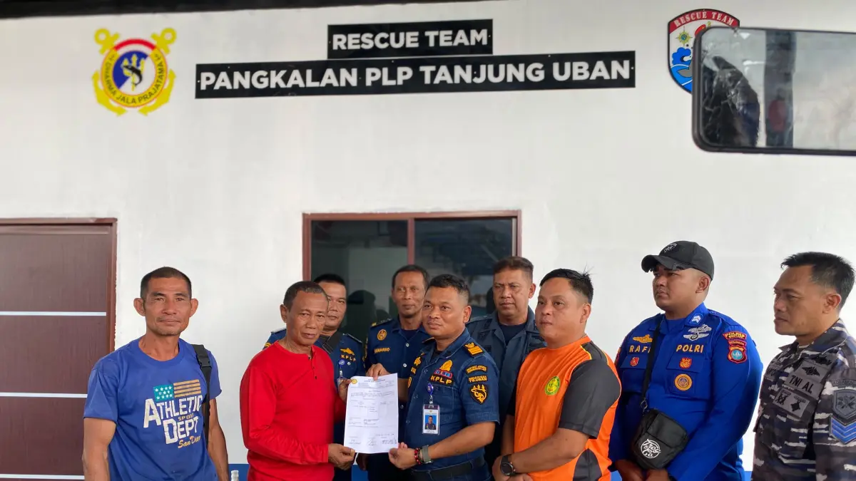 Koordinator Operasi Pangkalan PLP Tanjunguban, Alfaizul (kanan) menyerahkan korban kepada kerabat,Masdar di Pos Dermaga Pangkalan PLP Tanjunguban, Selasa (7/7/2026). F.Alfaizul untuk Batam Pos