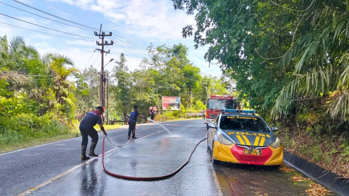 Petugas Damkar membersihkan jalan yang terkena tumpahan minyak solar di Jalan Raya Wisata Bahari, tepatnya di depan Hotel Bhadra, Kecamatan Toapaya, Bintan, Rabu (8/7/2026). F.Makmur untuk Batam Pos