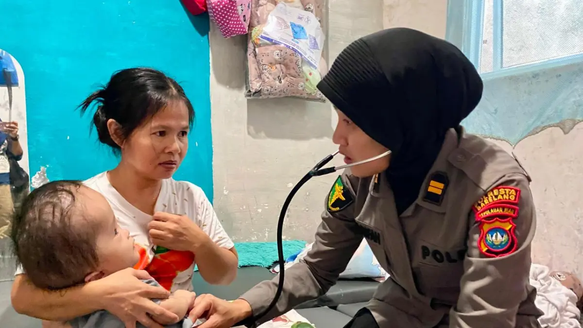 Kasidokkes Polresta Barelang, Iptu.dr Syarifah saat memeriksa Helena, bayi 8 bulan yang menderita hidrosefalus yang digendong sang ibu, Watina Lala di kontrakannya di Kavling Senjulung, Kabil, Nongsa, Kamis (9/7/2026). F Ist untuk Batam Pos