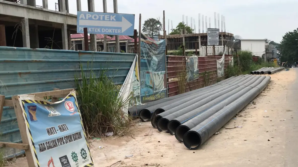 Pipa distribusi air bersih proyek perkuatan jaringan Batuampar–Bengkong terlihat masih terpasang di sisi Jalan Bengkong Sadai, Kota Batam, Jumat (10/7) siang. F.Sya