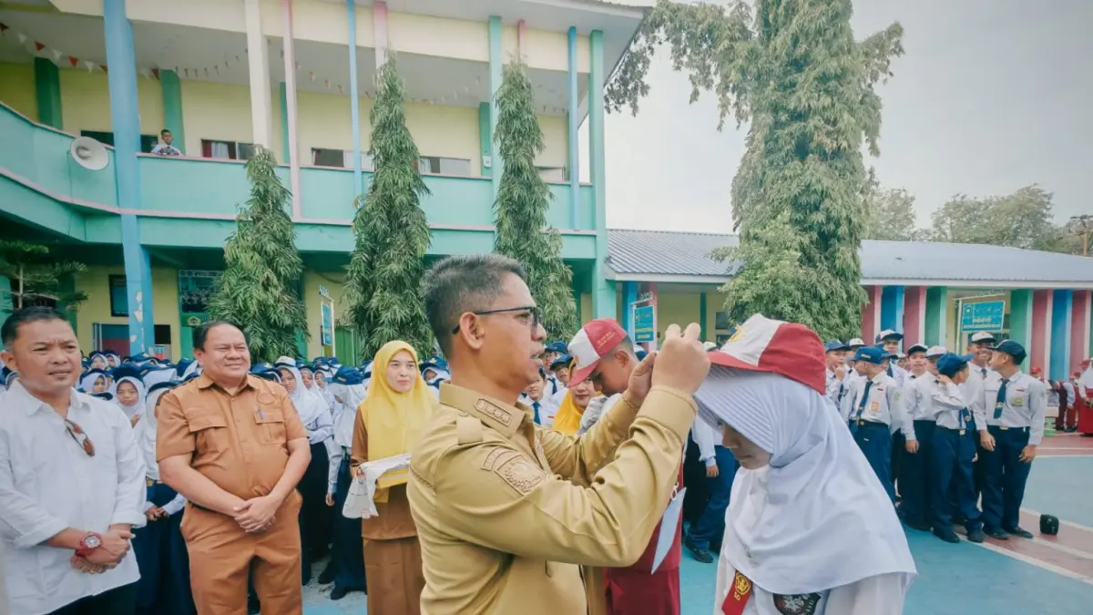 Bupati Karimun Iskandarsyah mengalungkan tanda peserta kepada siswa baru saat pembukaan MPLS Ramah di SMP Negeri 1 Karimun. F. Sandi Pramosinto/Batam Pos