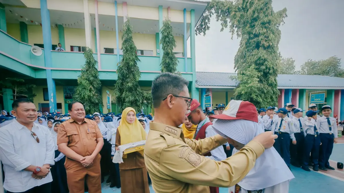 Bupati Karimun, Iskandarsyah mengalungkan tanda peserta MPLS Ramah kepada siswa baru sebagai tanda dimulainya masa orientasi siswa tahun ajaran baru 2026/2027 di Karimun, Senin (13/7/2026). F Sandi Pramosinto/Batam Pos