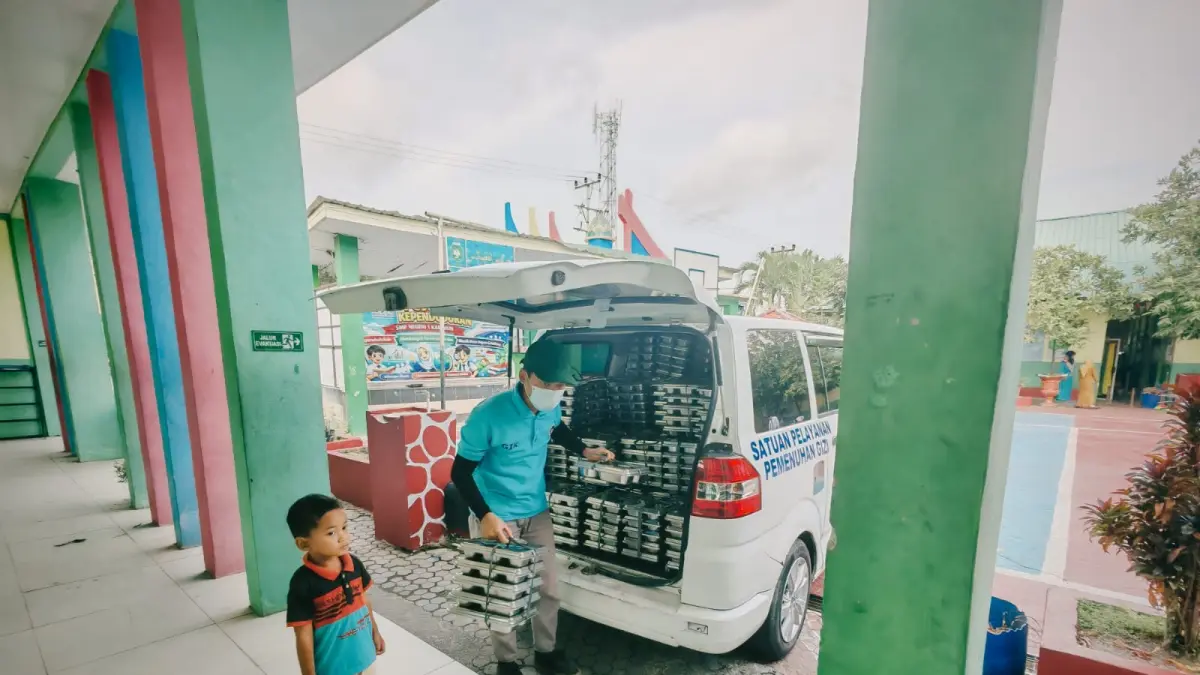 Petugas dari salah satu dapur SPPG menyalurkan Makan Bergizi Gratis (MBG) ke salah satu sekolah di Kabupaten Karimun, Senin (13/7/2026). F Sandi Pramosinto/Batam Pos
