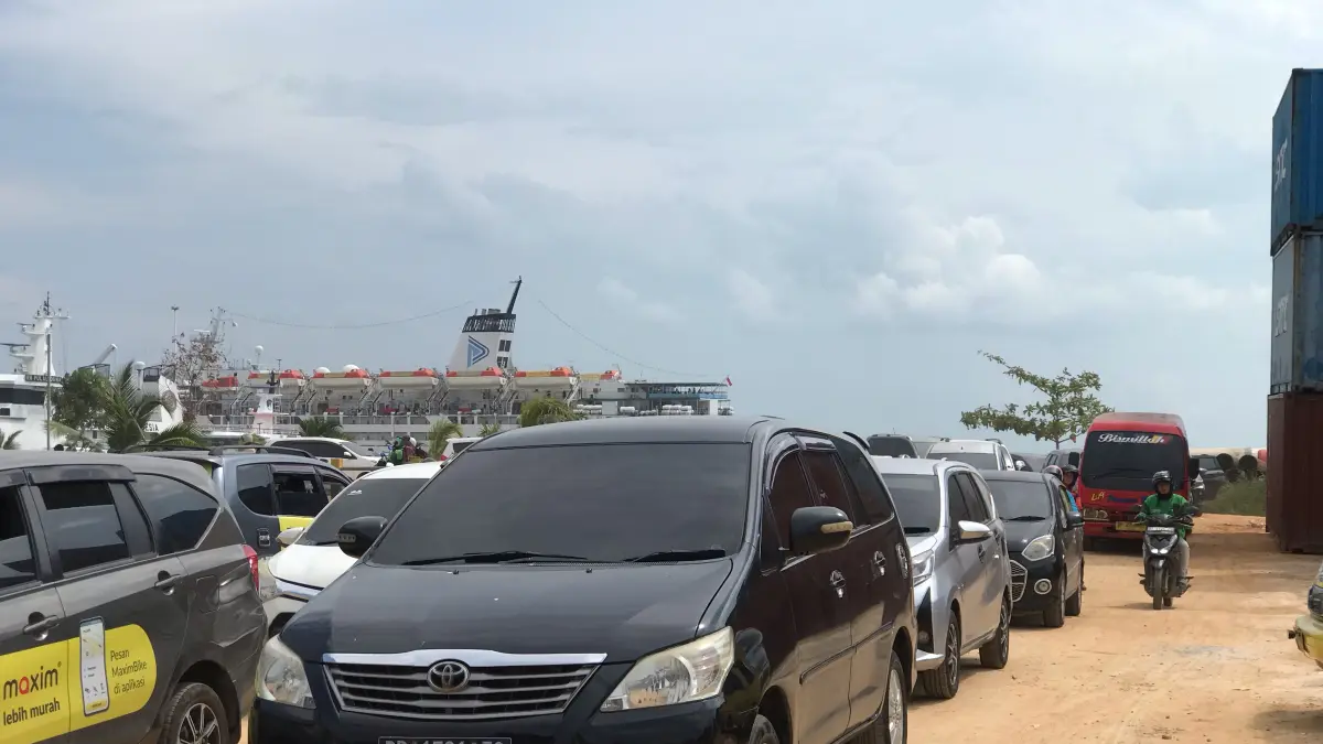 Kondisi akses menuju Pelabuhan Penumpang Batuampar, Batam, dipenuhi debu dan kemacetan saat aktivitas keberangkatan penumpang, Rabu (15/7). Penumpang mengeluhkan jalan yang belum beraspal, minimnya fasilitas, serta padatnya arus kendaraan yang dinilai mengurangi kenyamanan di tengah kenaikan tarif layanan pelabuhan. (Foto: M. Sya