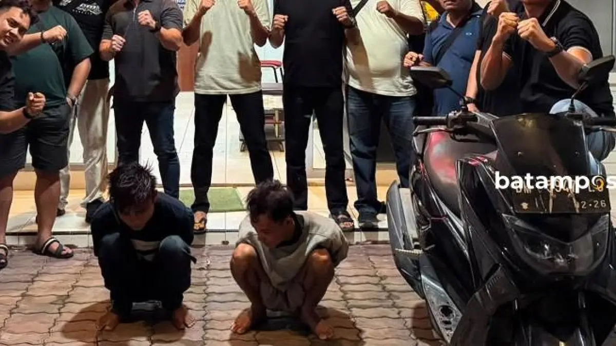 Dua terduga pelaku jambret di Batubesar, Nongsa (duduk bawah) berfoto bersama tim gabungan dari Polresta Barelang, Polsek Nongsa, dan Polsek Seibeduk, usai membekuk kedua terduga pelaku di salah satu rumah di Kaveling Mawar, Piayu, Senin (13/7) malam. Foto: Polsek Nongsa
