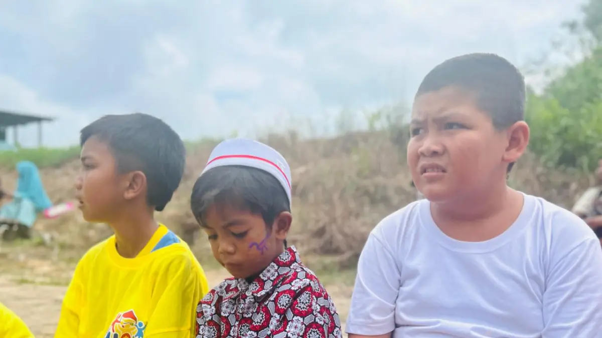 Aleando alias Bule,9 (kanan) duduk di pinggir lapangan bersama anak lainnya menunggu permainan baru dimulai. F Chahaya Simanjuntak/Batam Pos