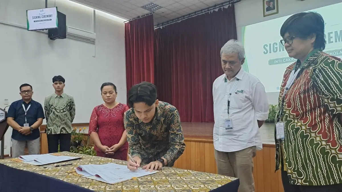 Jefri Silitonga, salah satu penerima beasiswa didampingi ibunya, Rosmina saat menandatangani perjanjian di Auditorium Wisma BIIE pada Jumat (24/7/2026). F. Slamet Nofasusanto/Batam Pos