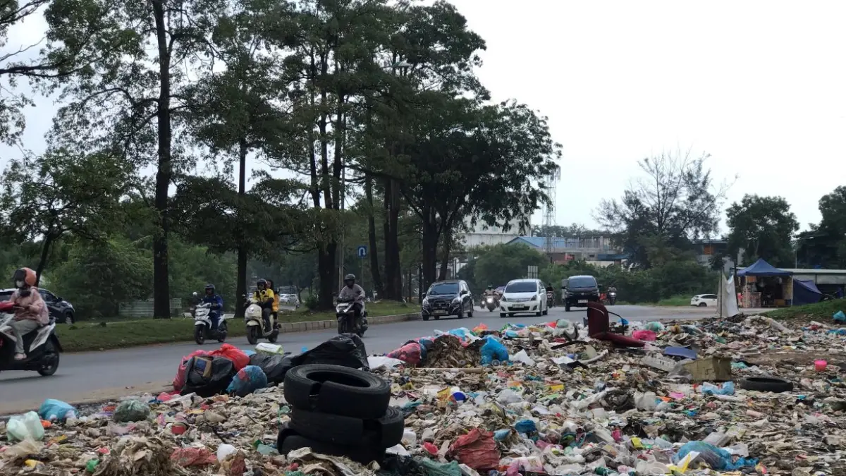 Pengendara roda dua dan roda empat melintas di depan tumpukan sampah liar di tepi Jalan Yos Sudarso, Batuampar, Jumat (24/7). Foto: M. Sya