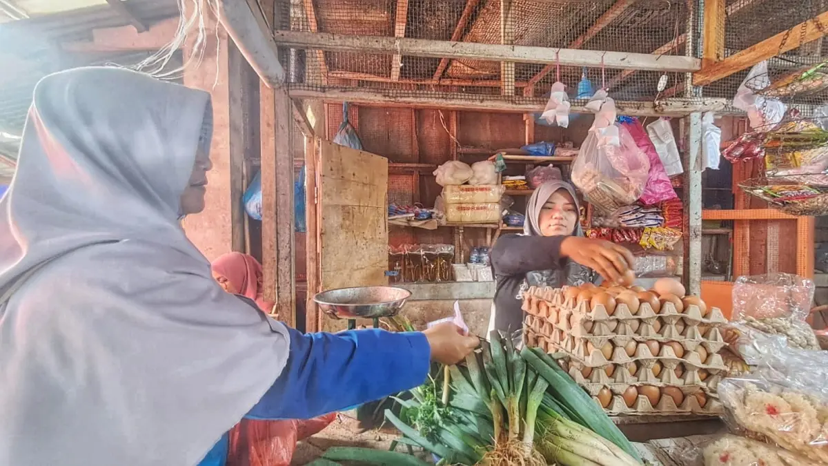 Pedagang Pasar Baru, Tanjunguban, Nining Sulasih melayani pembeli yang membeli telur, Jumat (24/7/2026). F.Slamet Nofasusanto/Batam Pos