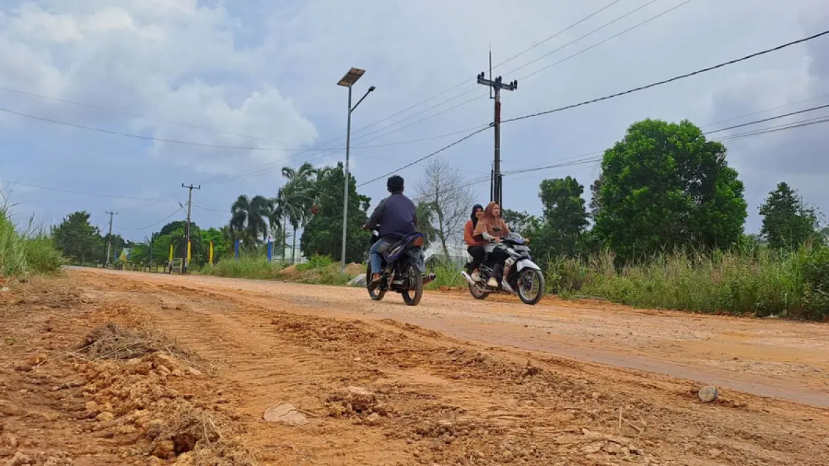 Pengendara melintas di Jalan Agro, Desa Gunung Kijang, Kecamatan Gunung Kijang yang sudah ditambal dengan tanah, Selasa (28/7/2026). F.Slamet Nofasusanto/Batam Pos.