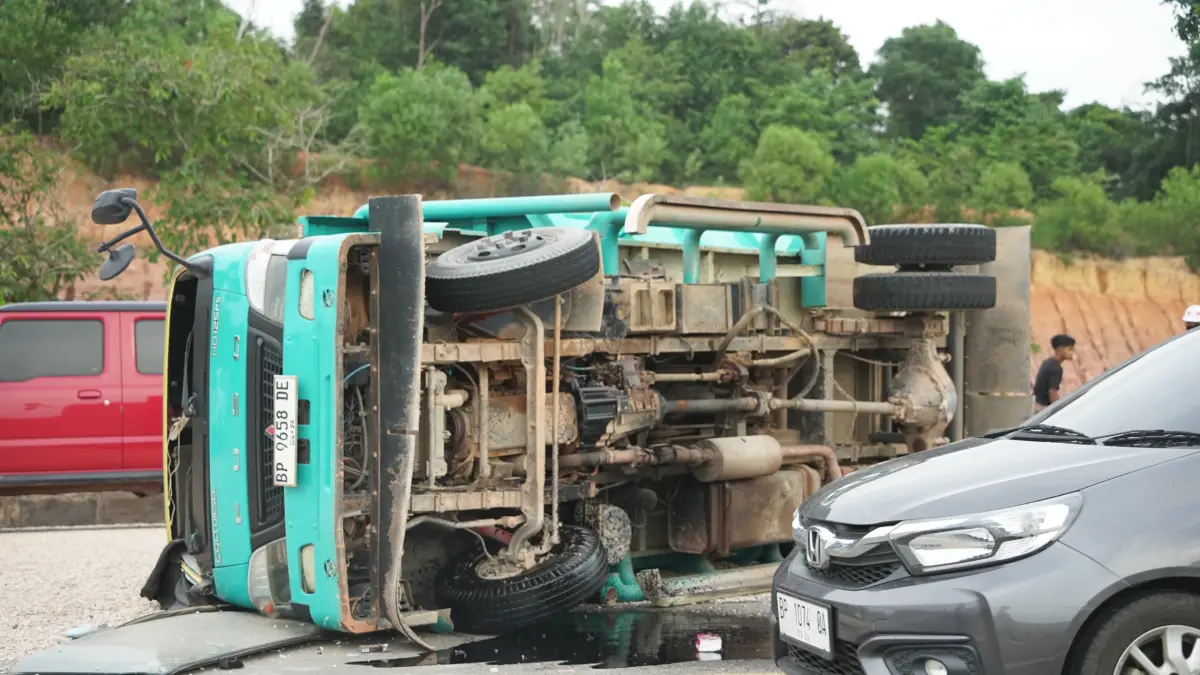 Sebuah truk bermuatan koral terbalik saat hendak berputar balik di u-turn kawasan KDA Luar, Jalan menuju Bandara Internasional Hang Nadim, Batam, Selasa (28/7).
