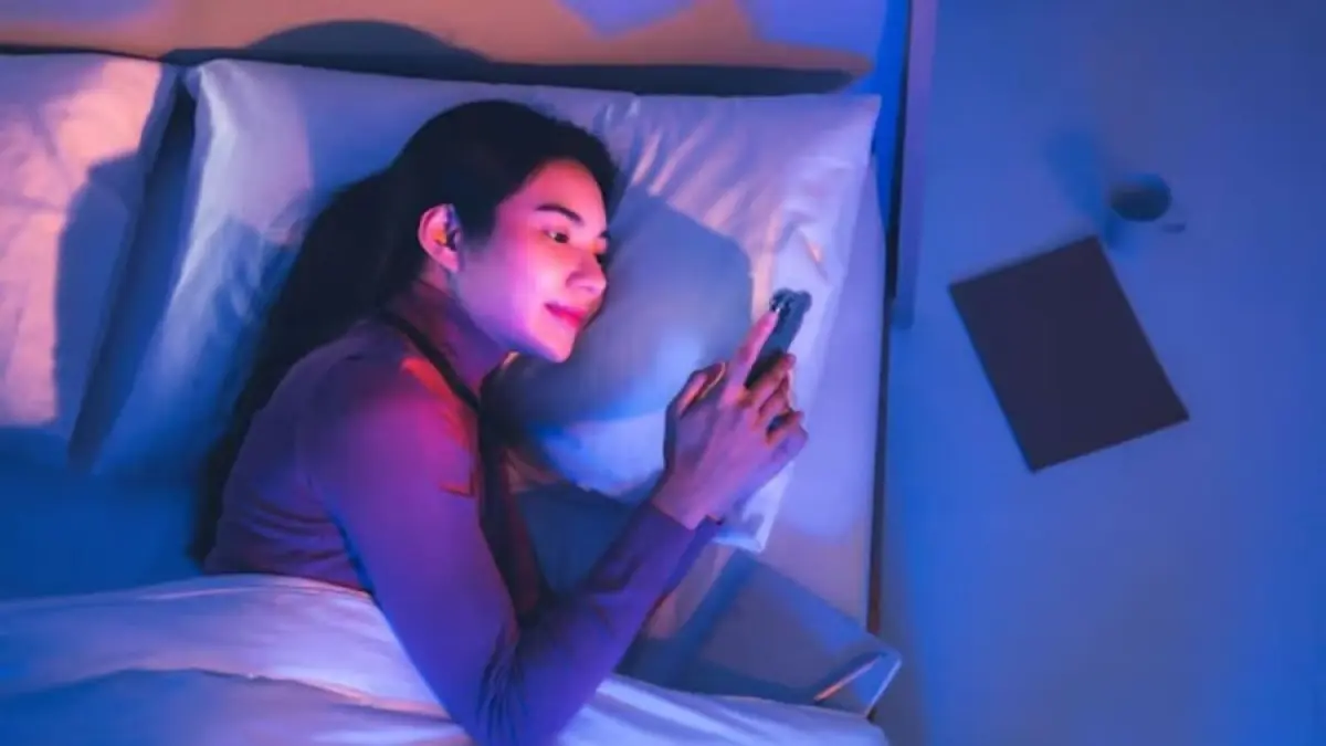ilustrasi orang yang bermain ponsel sebelum tidur. Sumber foto: Freepik