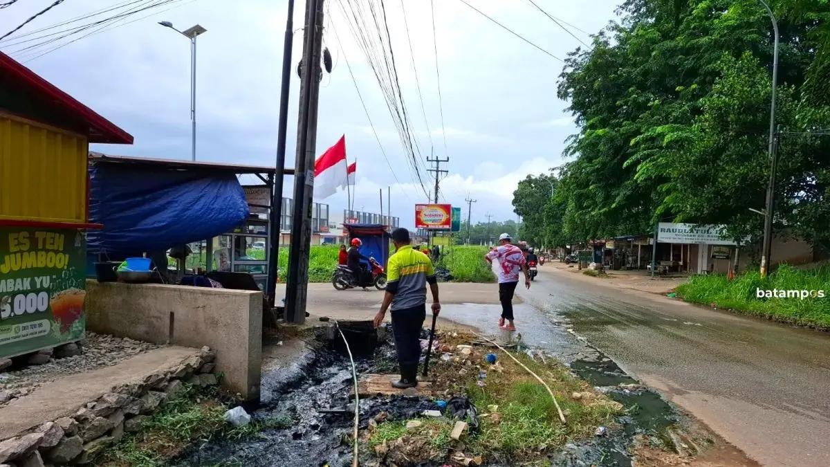 Petugas Dinas Bina Marga dan Sumber Daya Air Kota Batam membersihkan saluran drainase yang tersumbat di Jalan S. Parman, kawasan Piayu Laut, Kecamatan Sei Beduk. Istimewa.