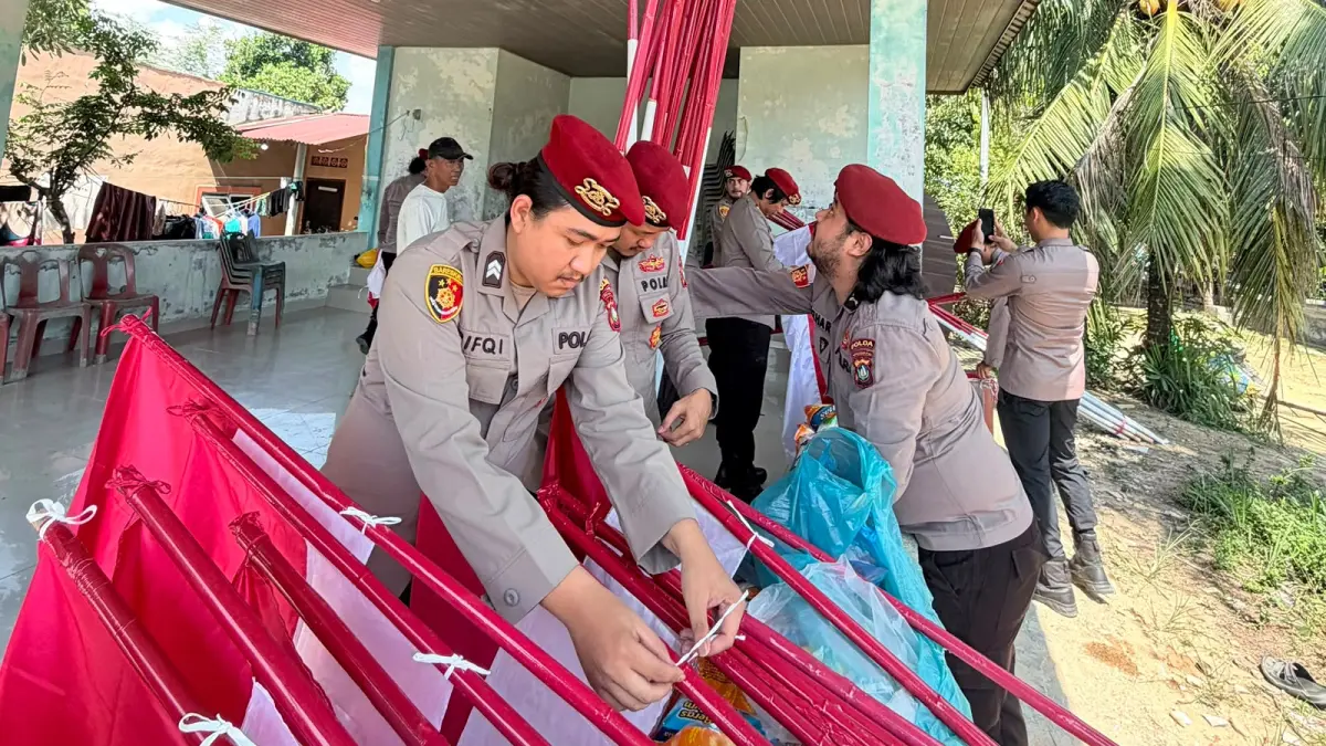 Personel Ditreskrimum Polda Kepri membagikan bendera dalam rangka menyambut Hari Ulang Tahun (HUT) ke-81 Kemerdekaan Republik Indonesia. F. Yashinta/Batam Pos