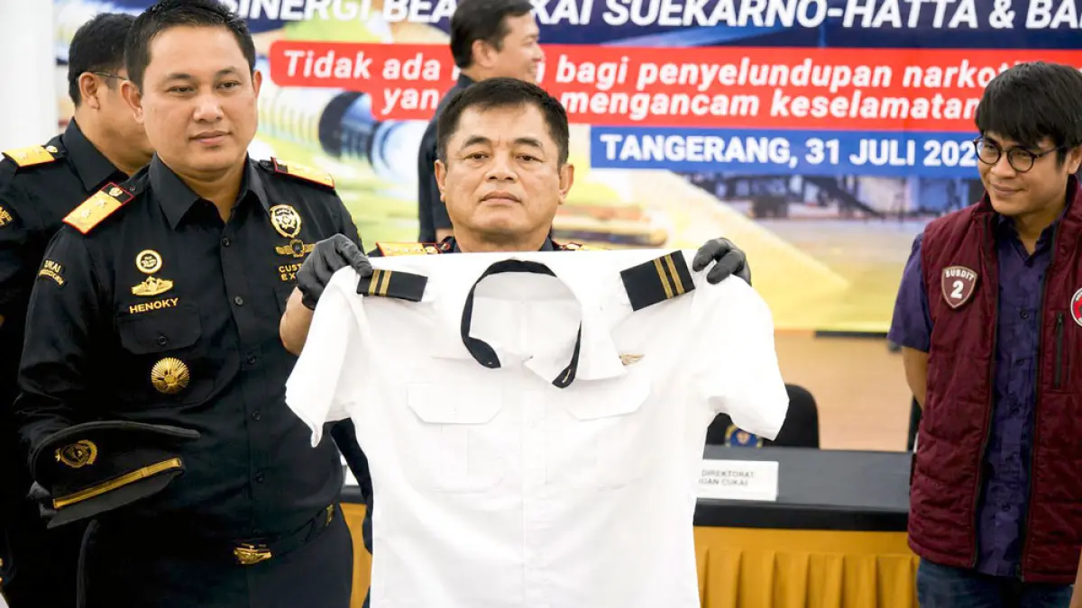 Dirjen BC, Djaka Budhi Utama (tengah) didampingi jajaran dan pihak kepolisian menunjukkan seragam pilot milik tersangka di Kantor BC Bandara Soekarno-Hatta, Tangerang, Jumat (31/7). Foto: ANTARA FOTO/Muhammad Iqbal/kye