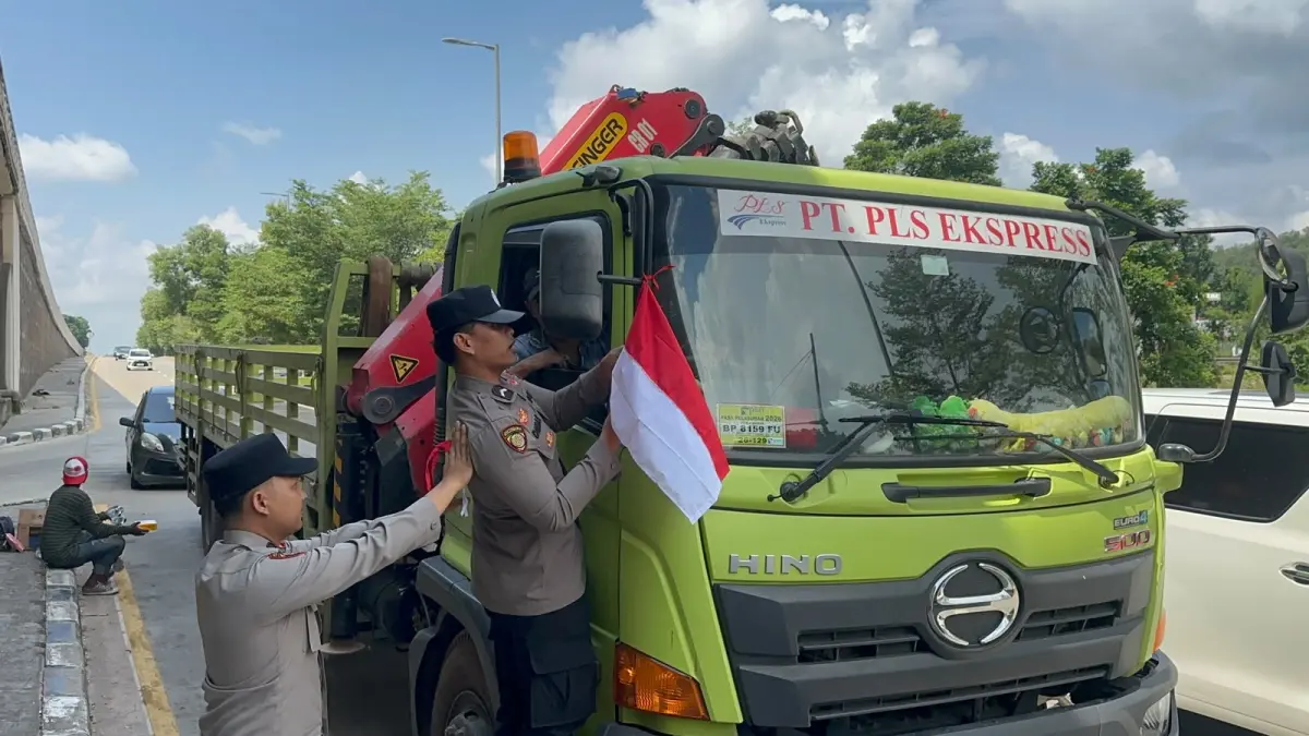 Jajaran Polresta barelang bagikan bendera kepada pengendara. F.Istimewa 
