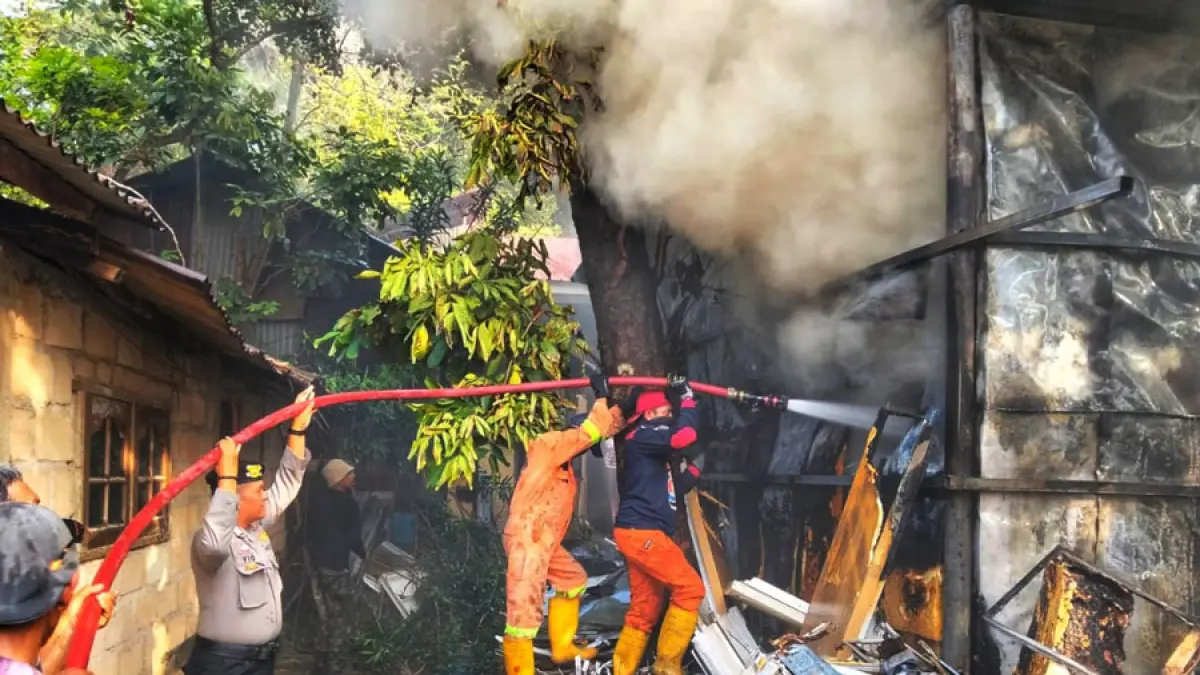 
Petugas kepolisian bersama personel Damkar dan warga berupaya memadamkan kebakaran yang menghanguskan gudang elektronik di Jalan Pasar Berdikari, Kelurahan Kijang Kota, Kecamatan Bintan Timur, Kamis (6/8). Kerugian akibat kebakaran diperkirakan mencapai Rp300 juta.  F.Kiriman HP Bako untuk Batam Pos.