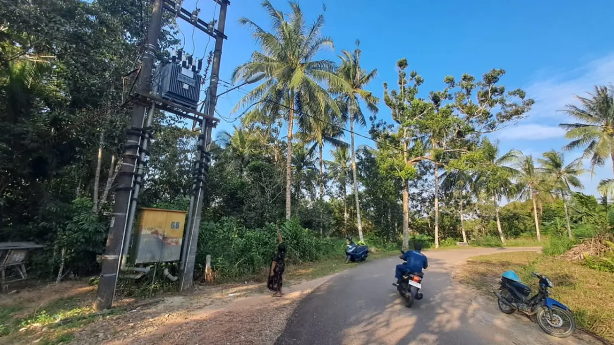 Warga Kampung Sungai Jeram, Ayu, menunjukkan lampu penerangan jalan umum (PJU) yang telah padam selama kurang lebih satu tahun. Foto: Slamet Nofasusanto/Batam Pos